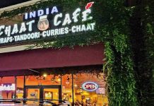 Nighttime view of Indian Chaat Cafe - A vibrant and bustling Indian restaurant illuminated with warm lights, creating a lively and inviting atmosphere